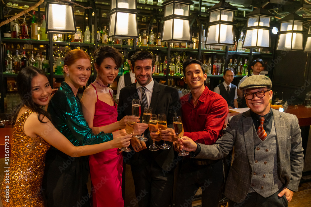 Group of Diversity people celebrating and toasting champagne glass together at luxury restaurant bar. Happy man and woman friends enjoy and fun holiday hangout party meeting nightlife at nightclub