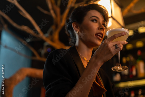 Portrait of Attractive Caucasian woman relax and enjoy hangout nightlife and drinking fancy cocktail at luxury restaurant bar. Beautiful female celebrating holiday event party at nightclub in the city