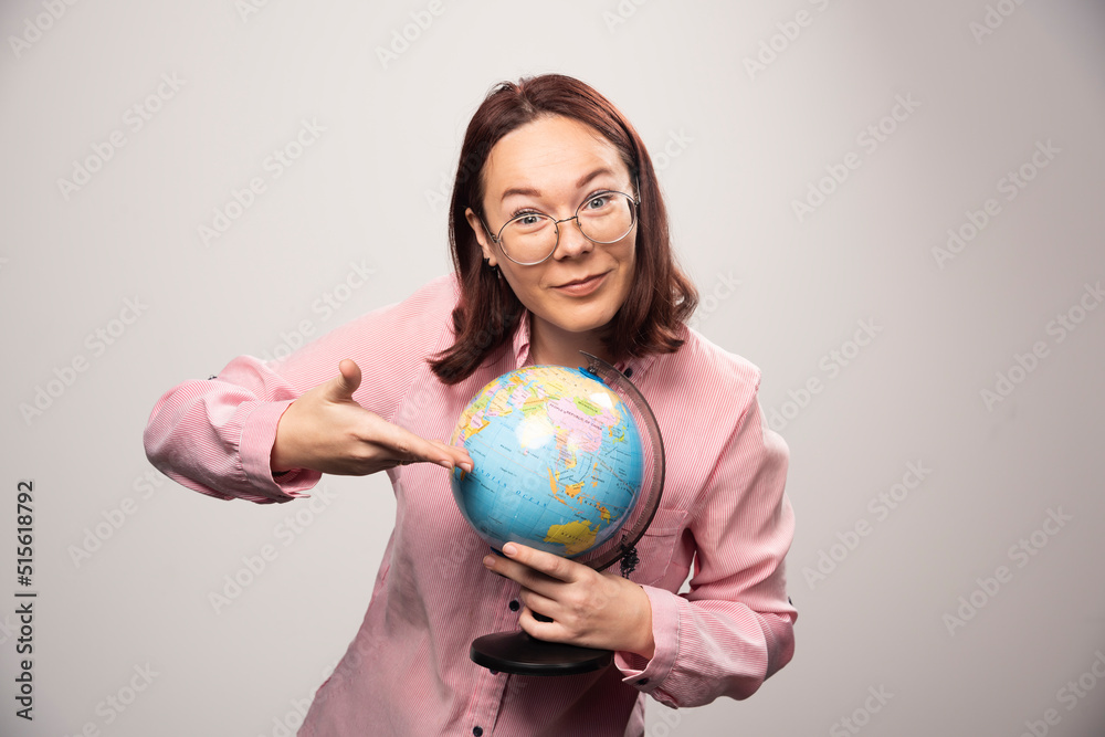 Portrait of woman showing an Earth globe on a white background Portrait of woman showing an Earth globe on a white background