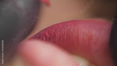 Close-up of a permanent makeup procedure. A needle pierces the lips and injects paint under the skin. Macro