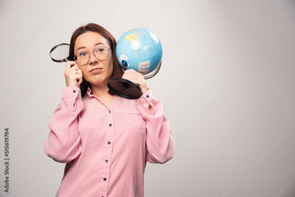 Portrait of woman holding a magnifying glass and Earth globe Portrait of woman holding a magnifying glass and Earth globe