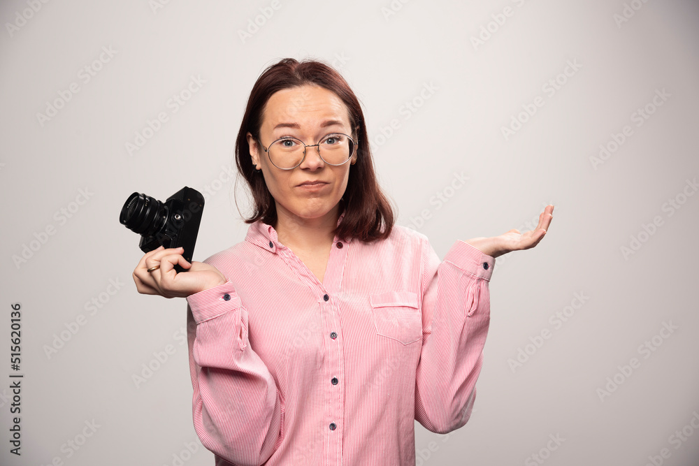 Woman photographer holding a camera on a white background Woman photographer holding a camera on a white background