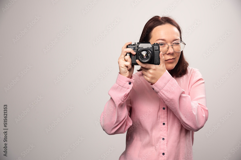 Woman taking a picture with camera on white background Woman taking a picture with camera on white background