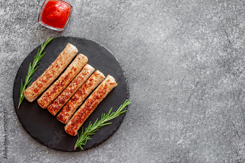 grilled turkey sausages on stone background with copy space for your text