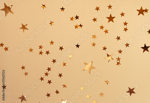 Golden stars glittering confetti on yellow background. Trendy festive holiday backdrop. Many star-shaped particles for a postcard, invintation or web banner © Lavsketch