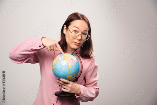 Portrait of woman showing an Earth globe on a white background © azerbaijan-stockers