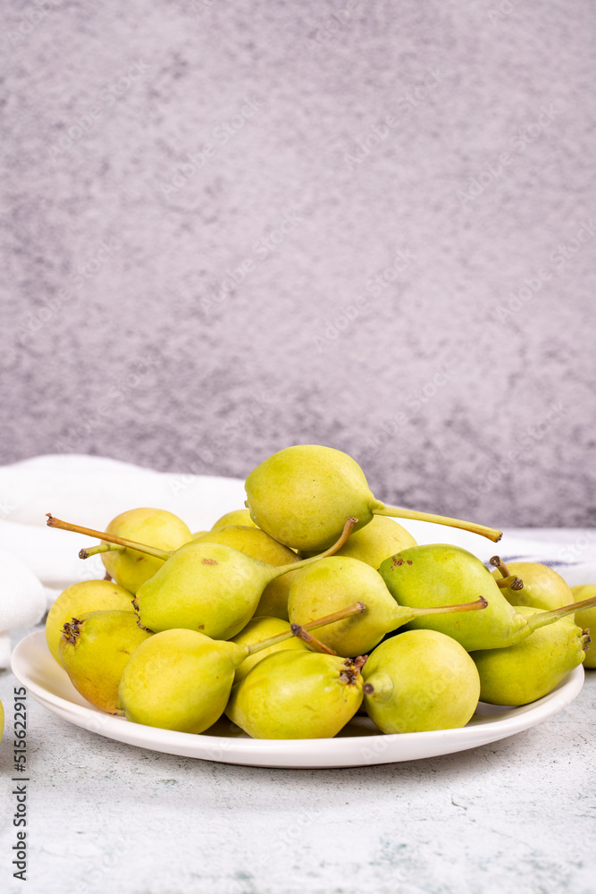 Fresh pear. Ripe pears in plate on stone background. Bulk pear. close up Fresh pear. Ripe pears in plate on stone background. Bulk pear. close up