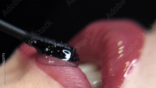 Lips are covered with a transparent medical gel.Macro.Black background.