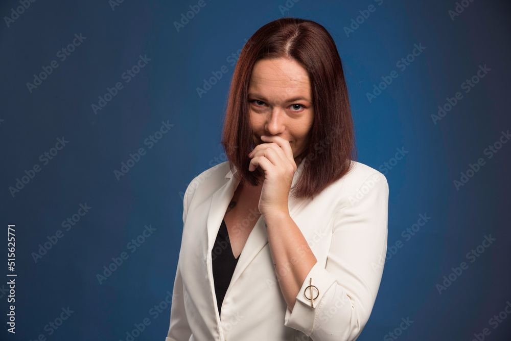 Young businesswoman in white blazer smiling secretly Young businesswoman in white blazer smiling secretly