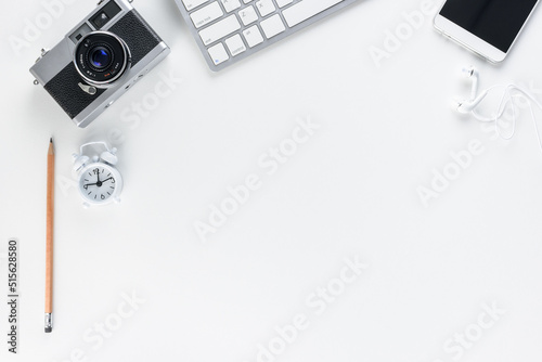 Top or above view, flat lay of office supply on designer desk table, business / personal work space, desktop keyboard, pencil, mobile phone, clock, blank, empty space for text or schedule. White theme photo