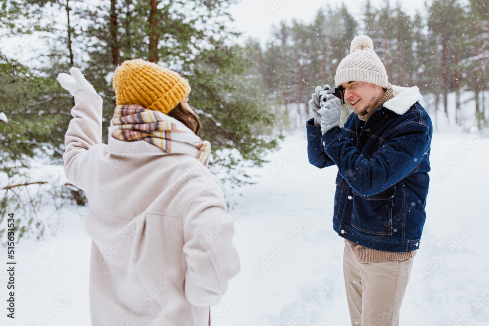 Φωτογραφία people, love and leisure concept - happy smiling man photographing woman in wint