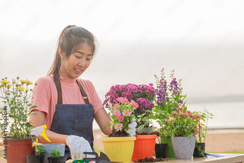 Portrait of asian woman wearing gloves planting flowers at outdoor