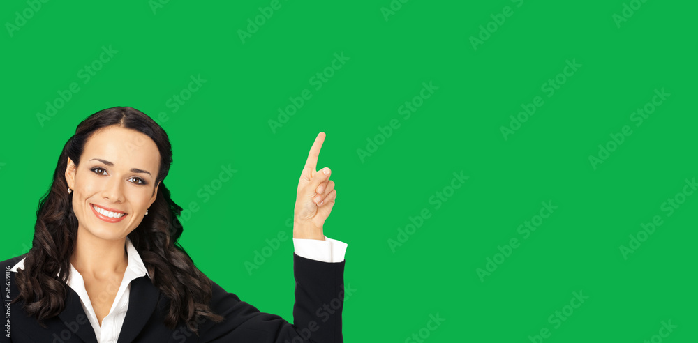 Young happy smiling woman in black confident suit, showing pointing at copy space. Business concept. Isolated on vivid green background. Brunette businesswoman. Empty area for text. Young happy smiling woman in black confident suit, showing pointing at copy space. Business concept. Isolated on vivid green background. Brunette businesswoman. Empty area for text.