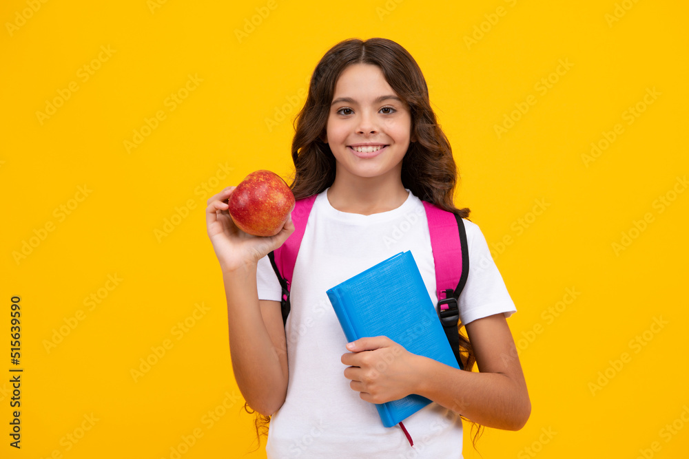 Back to school. Teenage school girl with bag hold apple and book, ready to learn. School child on isolated yellow studio background. Back to school. Teenage school girl with bag hold apple and book, ready to learn. School child on isolated yellow studio background.