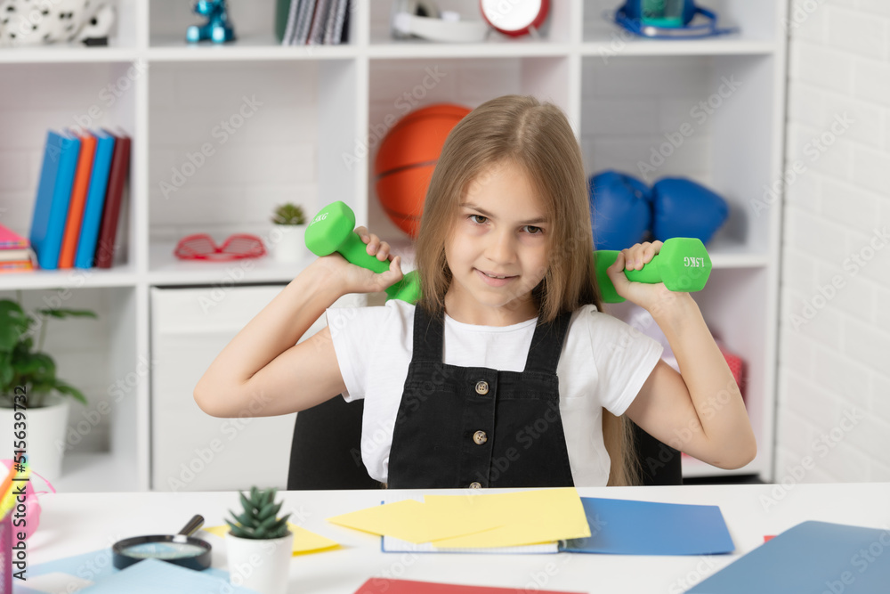 kid hold sport barbells in school classroom kid hold sport barbells in school classroom