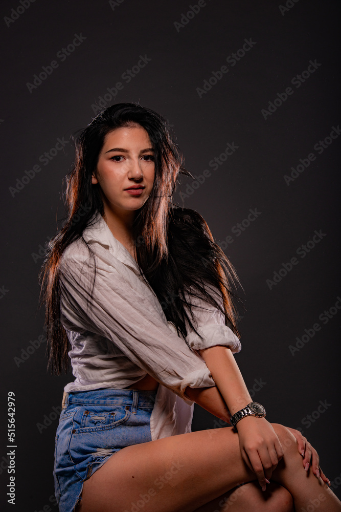 Posing and touching her leg while looking at the camera Posing and touching her leg while looking at the camera