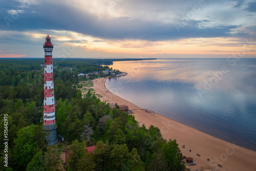 View of Osinovetsky lighthouse and Ladoga lake on summer sunset. Ladozhskoye Osero village, Leningrad Oblast, Russia.