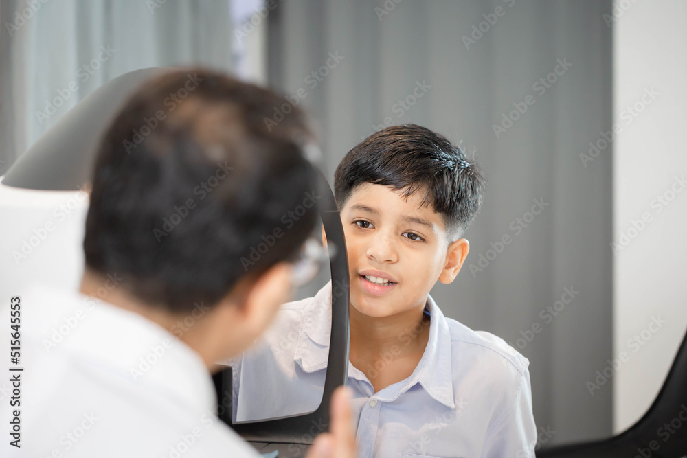 Boy doing eye test checking examination with autorefractor in optical shop, Optometrist doing sight testing for child patient, Eye doctor examinating kid patient Boy doing eye test checking examination with autorefractor in optical shop, Optometrist doing sight testing for child patient, Eye doctor examinating kid patient