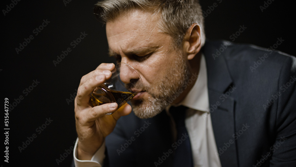 Businessman drinking whiskey, feeling lonely, problems in life and business Businessman drinking whiskey, feeling lonely, problems in life and business