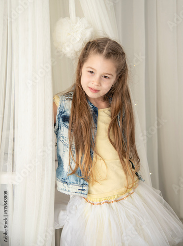 portrait of a girl in a yelloy dress and jeans jacket with long blond hair photo