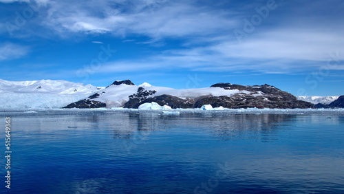 Icebergs floating at the base of a snow covered mountain  in the Southern Ocean  at Cierva Cove  Antarctica