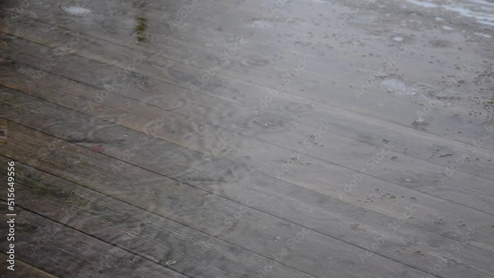 Raining on a wooden deck. Patio outdoors. Winters last snow melting in the rain. Springtime in Sweden. Raining on a wooden deck. Patio outdoors. Winters last snow melting in the rain. Springtime in Sweden.