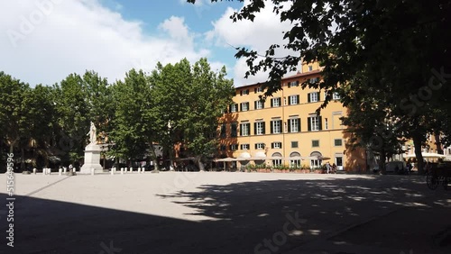 Steadicam shot of Square Piazza Napoleone in Lucca, Italy with large trees and statue  photo