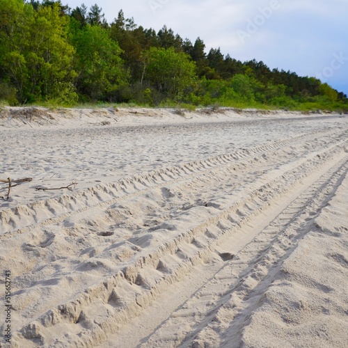 Bunch of footsteps and tire tracks on a beach in Pobierowo, Poland photo