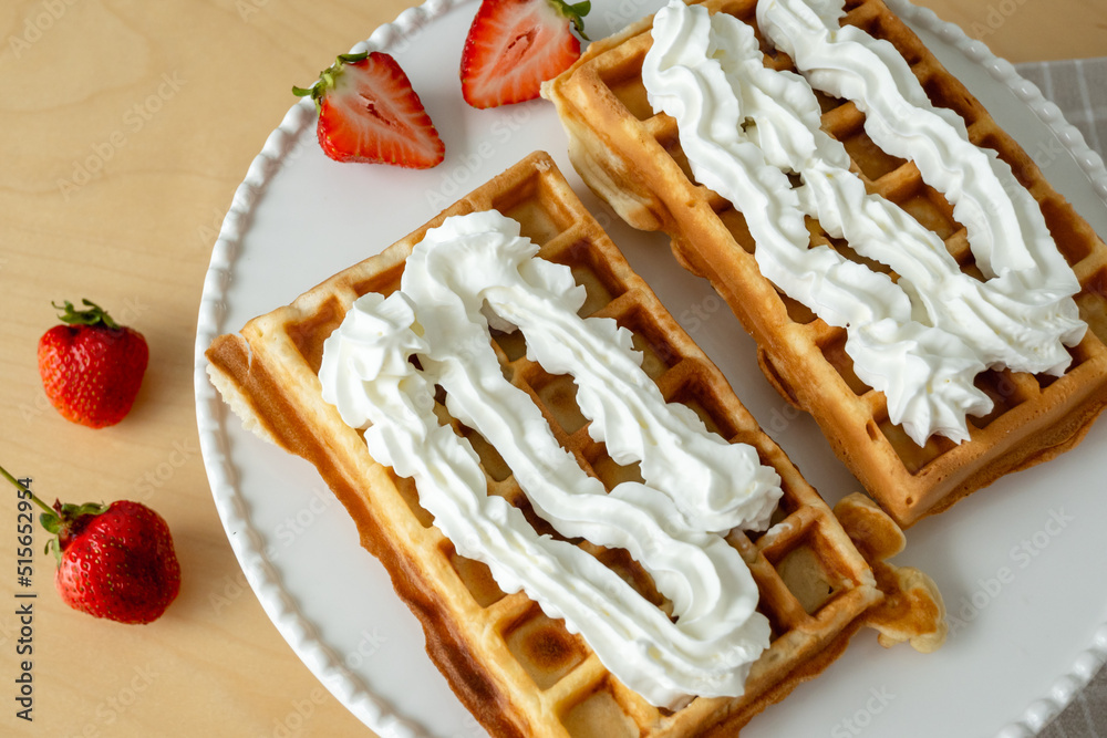 Homemade waffles with whipped cream and strawberries