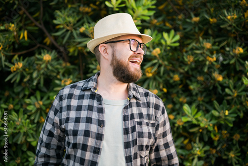 Portrait handsome laugh man over green bush outside - summer and emotional concept