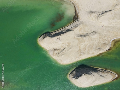 Beautiful aerial drone shot of the turquoise water of the ocean and the rocky beach photo