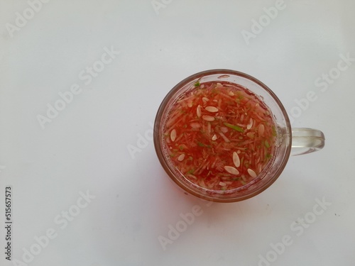 Strawberry flavored syrup with cucumber shavings (es kuwut) in a glass on a white background. restaurant background concept, healthy drinks, organic, business, finance, drink recipes, beverage, cafe photo