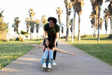 Beautiful couple having fun outdoors. Portrait of loving couple with skateboard...