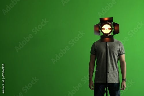 Man standing with a helmet of Game Virtual Machine and a green chroma in the background, copy space photo