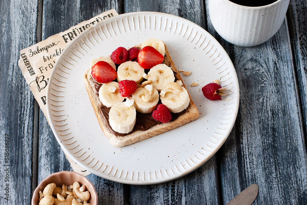 Breakfast toast with nut nougat cream, bananas and berries Breakfast toast with nut nougat cream, bananas and berries