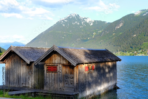 Leinwand Poster wooden hangar on water, boathouse for boats and boats on stilts, surface of moun