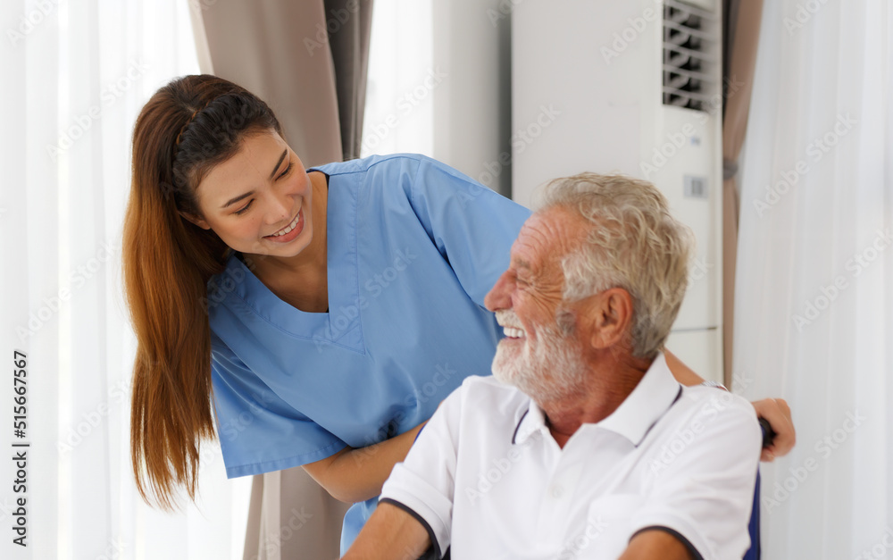 Fototapeta premium A nursing nurse with a Caucasian senior man in a wheelchair looking out the window.