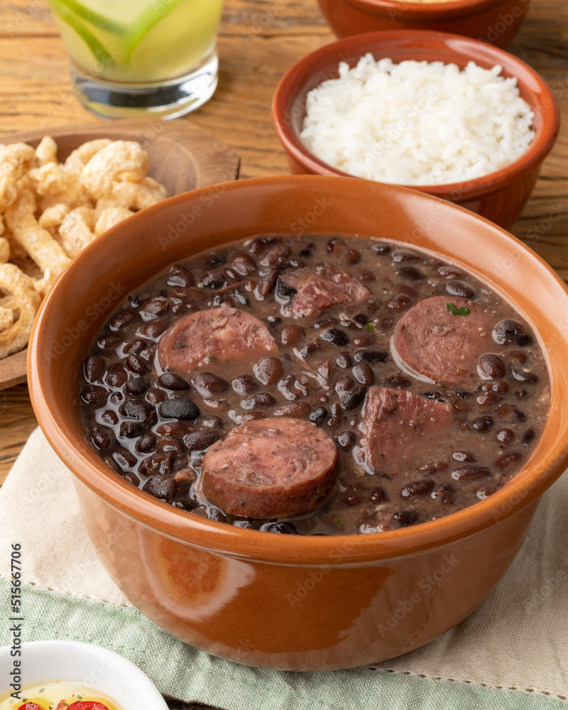 Typical brazilian feijoada with rice, caipirinha, farofa and cracklings Typical brazilian feijoada with rice, caipirinha, farofa and cracklings