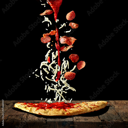 Pizza ingredients falling onto pizza bread