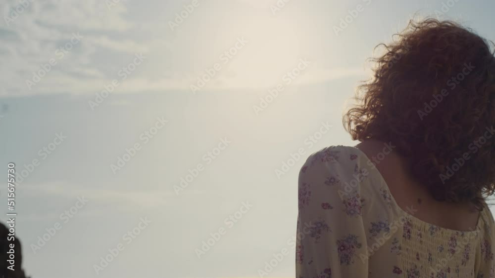 Unknown woman raising face to sunlight close up. Back view girl standing alone. Unknown woman raising face to sunlight close up. Back view girl standing alone.