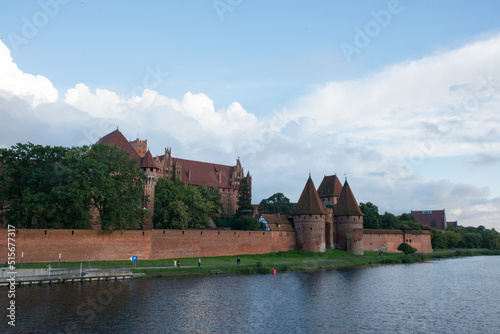 Beautiful view of Malbork castle next to the river. Fort and buildings.