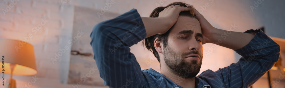 Young man touching head while suffering from insomnia at home, banner Young man touching head while suffering from insomnia at home, banner