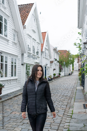 Young tourist in a street known for its typical Scandinavian white houses in Stavanger, Norway.