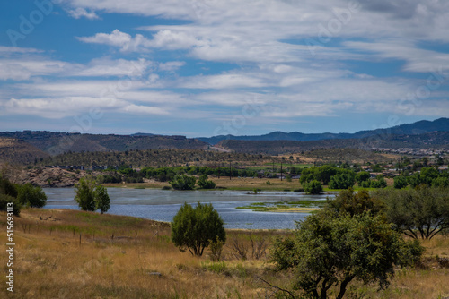 Fototapeta Naklejka Na Ścianę i Meble -  Prescott Arizona lake in the distance with desert trees in the foreground