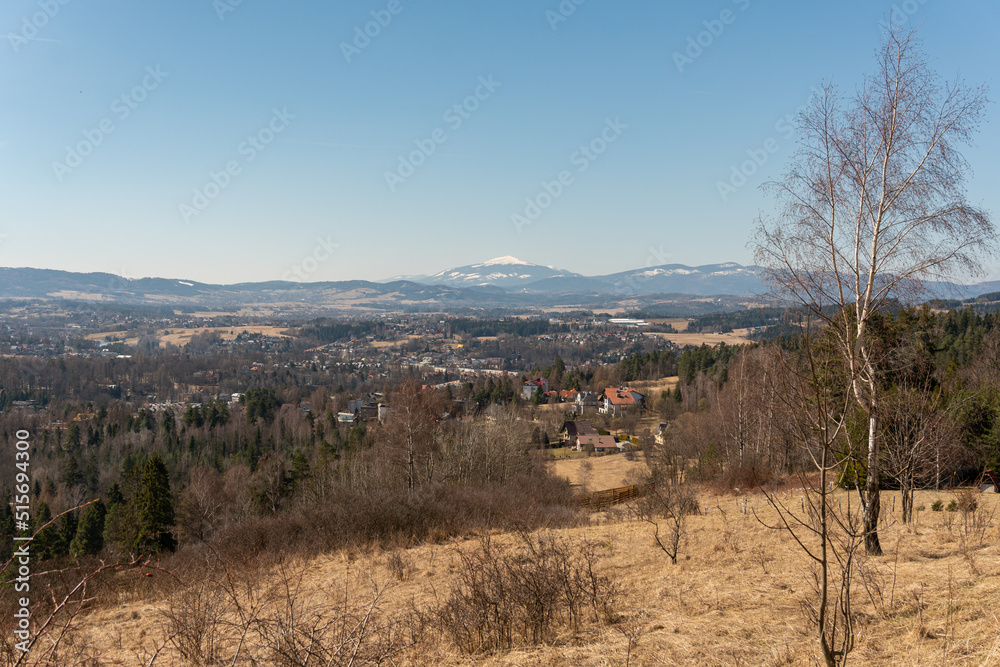 Breathtaking view on amazing snowy mountains and hills in spring, forest and village, panoramic landscape 