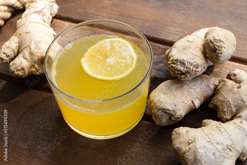 Alternative medicine, natural home remedy for cold and flu. Hot herbal tea with ginger and lemon over on wooden background