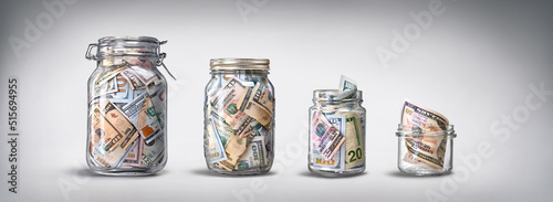 Four glass jars with savings, cash money (dollar banknotes) on grey background