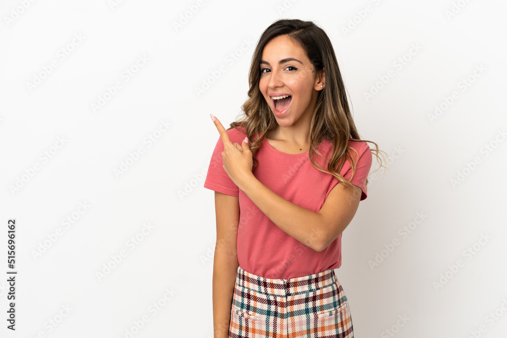 Young woman over isolated background surprised and pointing side Young woman over isolated background surprised and pointing side