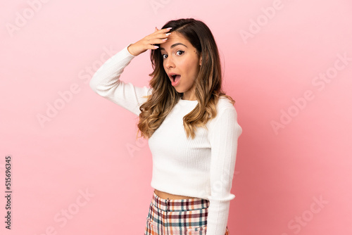 Young woman over isolated background doing surprise gesture while looking to the side