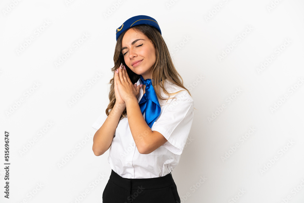 Airplane stewardess over isolated white background making sleep gesture in dorable expression Airplane stewardess over isolated white background making sleep gesture in dorable expression